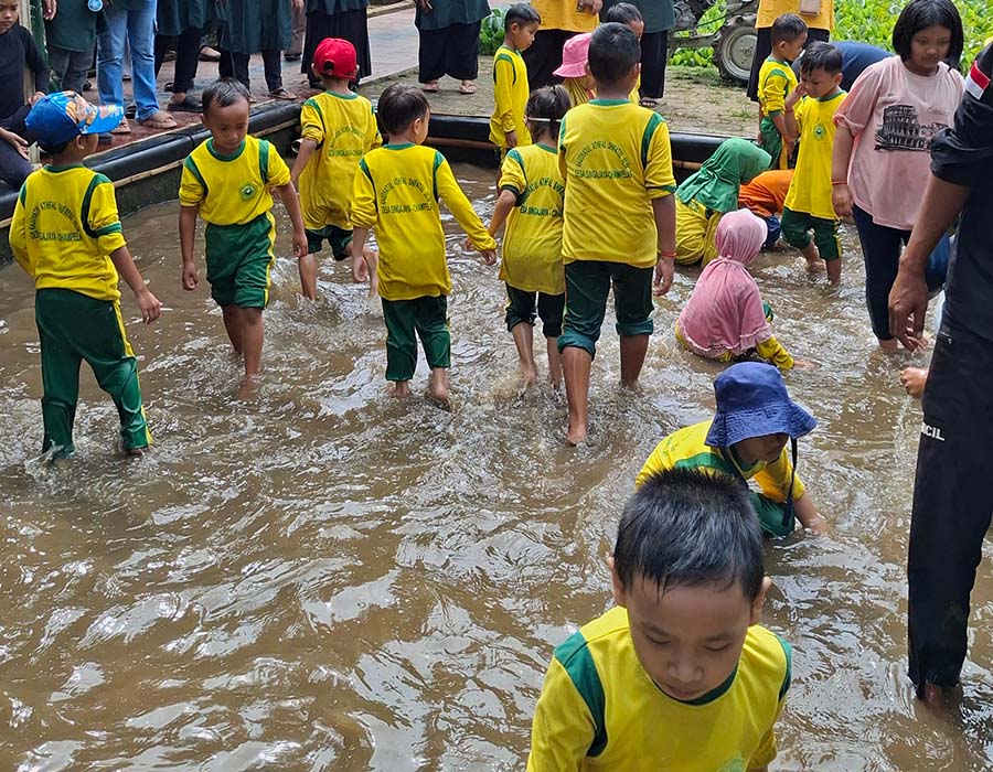 Anak-anak bermain air di kolam dangkal